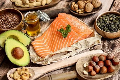 Tisch mit Avocado, Lachs, Nüssen und Öl