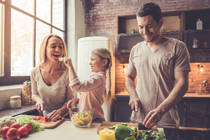 Vater und Mutter kochen mit ihrer Tochter