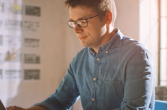 Mann mit Brille am Laptop in einem Büro