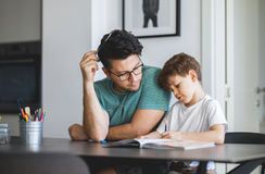 Junger Vater hilft Sohn bei den Hausaufgaben