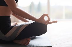 Frau im Schneidersitz macht Yoga